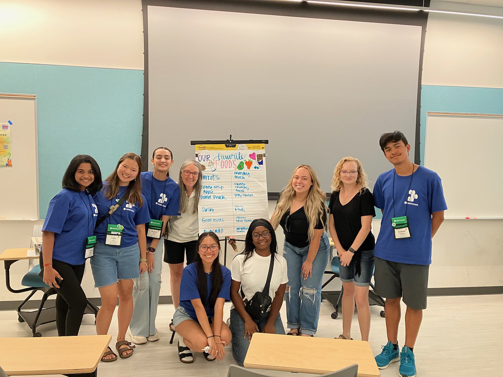 group of youth and adult advisor posing with display board