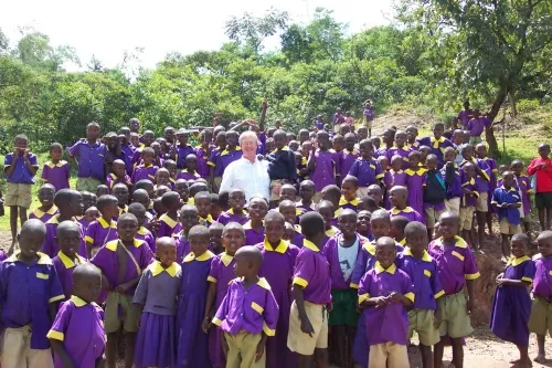 IN KENYA--UC Davis medical entomologist Thomas Scott, towers above schoolchildren in Kenya in a photo taken in 2004. (He's 6-foot, 6-inches tall.)