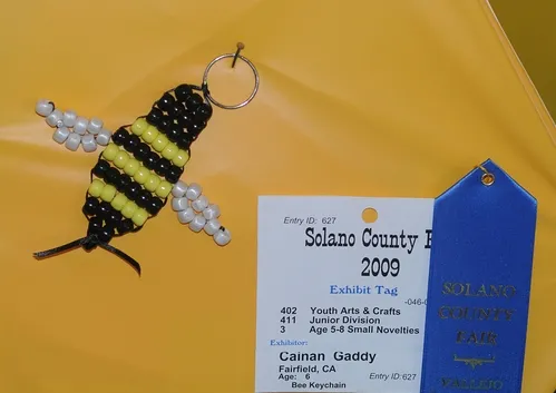A HONEY BEE is transformed into a key chain at McCormack Hall, Solano County Fair. This is the work of Cainan Gaddy, 6, of Fairfield. (Photo by Kathy Keatley Gavey)