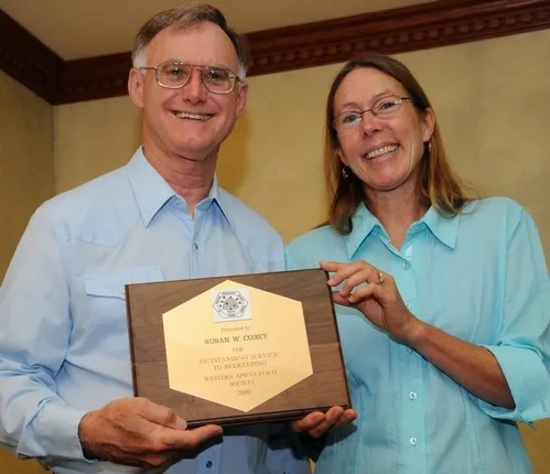 HIGH HONOR--UC Davis bee breeder-geneticist Susan Cobey receives the "Outstanding Service to Beekeeping" award at the Western Apicultural Society conference from president Eric Mussen, Extension apiculturist. (Photo by Kathy Keatley Garvey)