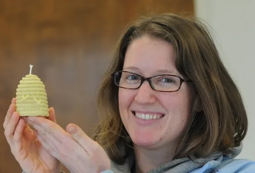 BEEKEEPER Elizabeth Frost shows a miniature beehive candle she made from beeswax and a little paraffin. (Photo by Kathy Keatley Garvey)