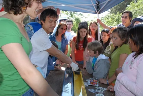 YAO HUA LAW is also known for his expertise at coordinating the annual cockroach races at UC Davis Picnic Day for the Department of Entomology. Here (second from left) he gears up for the next race. (Photo by Kathy Keatley Garvey)