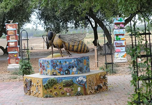 BEE SCULPTURE, titled "Miss Bee Haven," graces the Haagen-Dazs Honey Bee Haven at the Harry H. Laidlaw Jr. Honey Bee Research Facility, UC Davis. It is the work of noted artist Donna Billick. The ceramic tiles on the bench and the bee hive columns (back) are the work of the UC Davis Art/Science Fusion Program. (Photo by Kathy Keatley Garvey)
