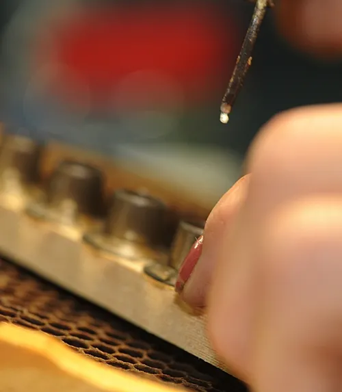 TINY EGG, a future honey bee queen, is moved from a comb to a queen cell cup at the Strachan Apiaries in Yuba City. (Photo by Kathy Keatley Garvey)