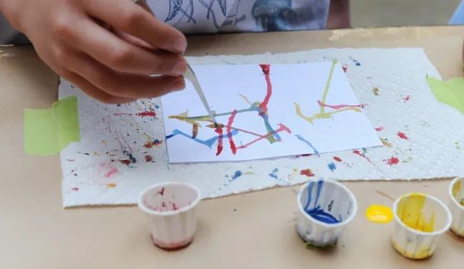 Children especially love Maggot Art. They dip the maggots into water-based paint and let the larvae crawl on the paper. All events are free. (Photo by Kathy Keatley Garvey)
