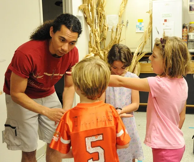 Ralph Washington, who has a bachelor's degree in entomology from UC Davis, talks about the hissers to Mick, Emme and Molly Dunning (right). (Photo by Kathy Keatley Garvey)