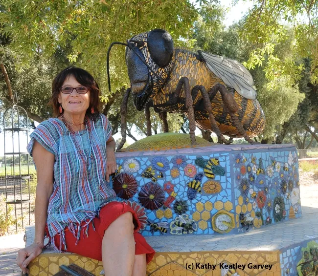Donna Billick with her ceramic mosaic sculpture of a honey bee in the Haagen-Dazs Honey Bee Haven. (Photo by Kathy Keatley Garvey)