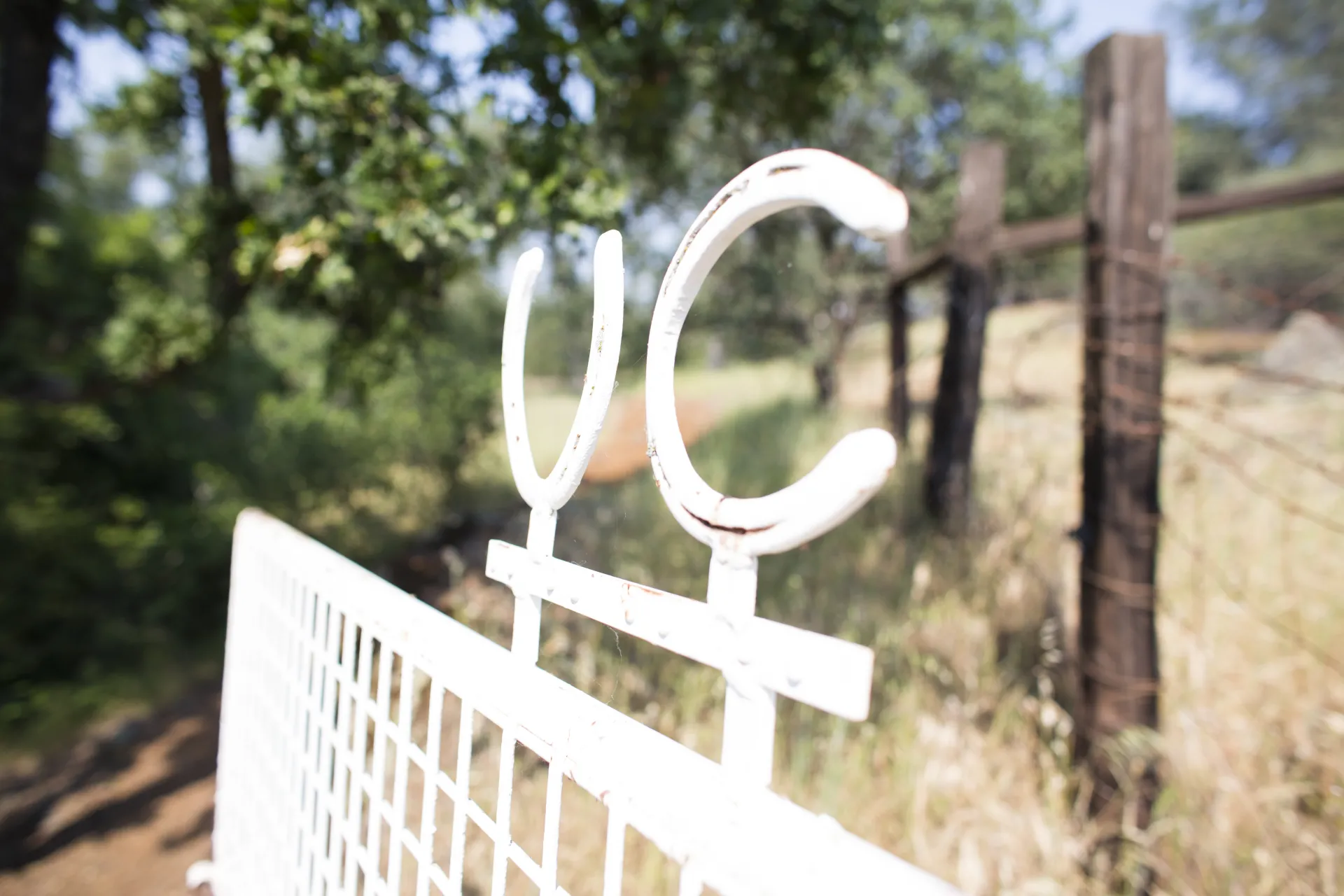 Image of 2 horseshoes and a metal bar depicting UC's livestock brand at our front gate.