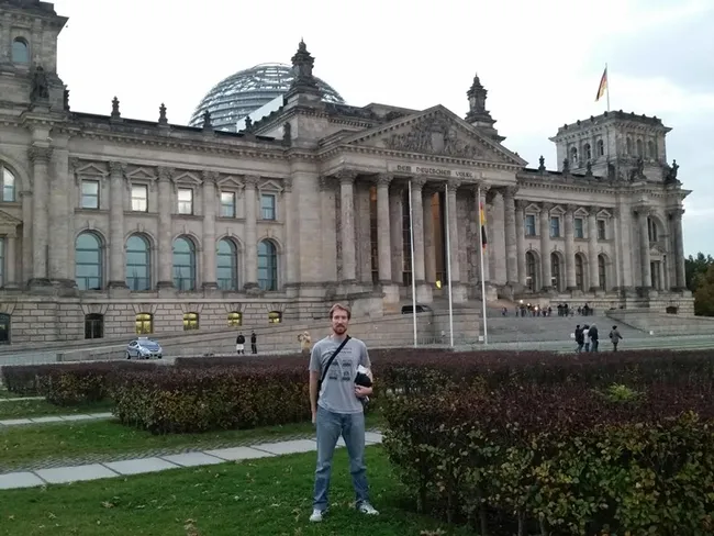 Matan Shelomi, wearing a UC Davis entomology shirt, stands in front of the Reichstag in Berlin.