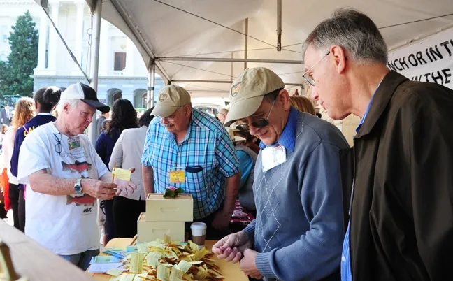 Readying the honey sticks for the crowd are beekeepers (from left) Bill Cervenka, Bob Sugar and Carlin Jupe and Extension apiculturist emeritus Eric Mussen. (Photo by Kathy Keatley Garvey)