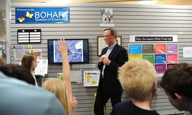 Children's author S. S. Dudley draws the attention of a crowd listening as he talks about the morpho butterflies. (Photo by Kathy Keatley Garvey)