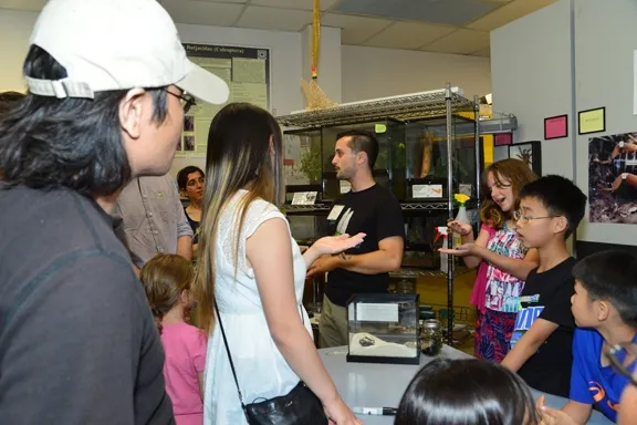UC Davis entomology student Wade Spencer (center, n black shirt) talks bugs to an enthusiastic crowd. (Photo by Kathy Keatley Garvey)