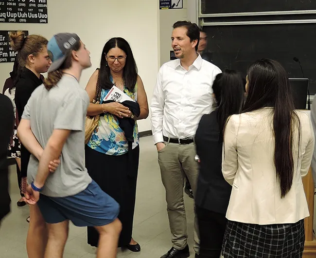 Dr. Emanual Maverakis (in white shirt), Department of Dermatology, UC Davis School of Medicine, answers questions after the symposium. (Photo by Kathy Keatley Garvey)