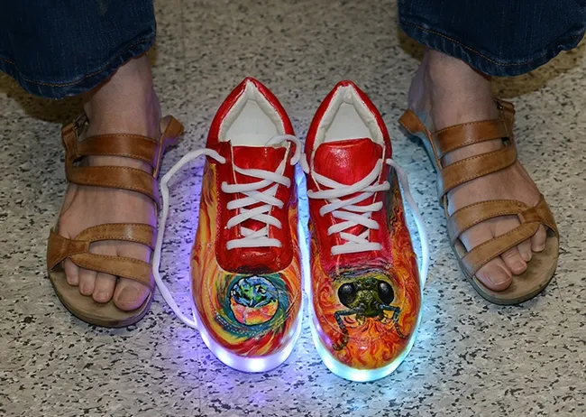 Lynn Kimsey gets ready to lace up her new shoes, painted with cuckoo wasps. (Photo by Kathy Keatley Garvey)