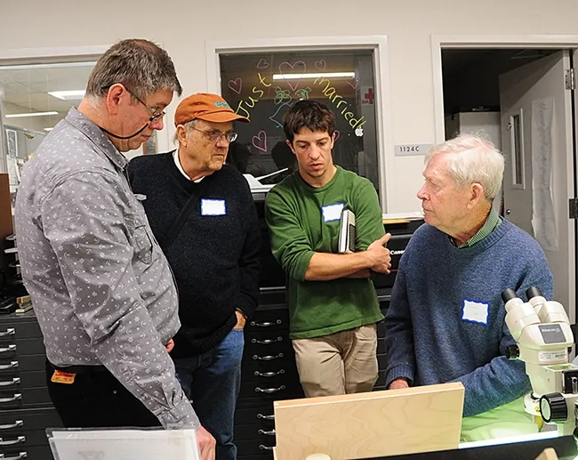 Entomologist Jerry Powell (seated at microscope) of Berkeley talks to colleagues. From left are entomologist Max Klepikov of Berkeley; distinguished professor Don Strong of tje UC Davis Department of Evolution and Ecology and UC Davis graduate student Eric Lopresti. Kleipkov holds a doctorate in entomology from his native Russia. (Photo by Kathy Keatley Garvey)