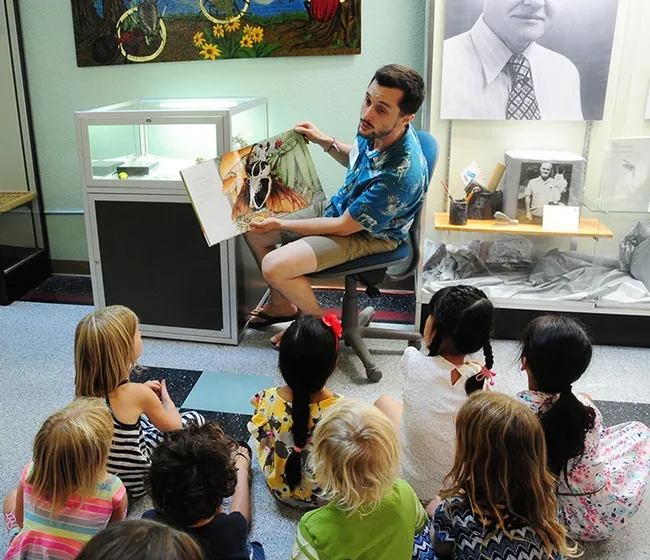 Entomologist Wade Spencer, a UC Davis undergraduate student and Bohart Museum associate, reads a children's book, "Beetle Bedlam." (Photo by Kathy Keatley Garvey)