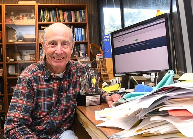 Bruce Hammock in his office in Briggs Hall, UC Davis, with his outstanding achievement award from the Eicosanoid Research Foundation. (Photo by Kathy Keatley Garvey)
