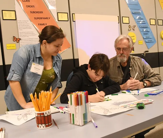 UC Davis student/artist Karissa Merritt talks about art with James Harris, 13, and his father, Rick Harris, who holds a master's degree in systemic entomology from UC Davis. (Photo by Kathy Keatley Garvey)