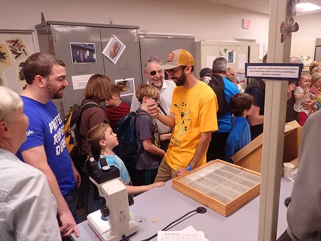 UC Davis entomology graduate Joel Hernandez talks about a walking stick or stick insect. (Photo by Kathy Keatley Garvey)