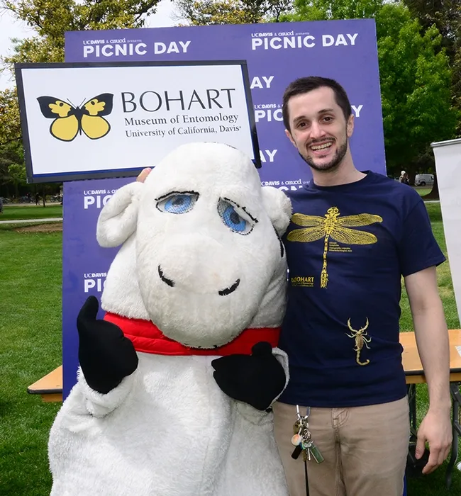 Bohart Museum associate Wade Spencer with his desert hair scorpion, Celeste, poses with the mascot, "Hamburger Cow Patty." (Photo by Kathy Keatley Garvey)