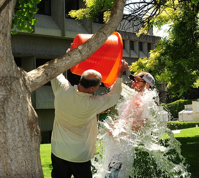 Water warrior Bruce Hammock dumps water on Kevin Cloonan, then a graduate student in the Walter Leal lab. (2012 photo by Kathy Keatley Garvey)