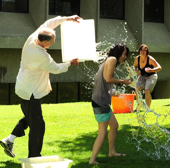 In this 2017 photo, Bruce Hammock douses Louisa Lo, who was his executive administrative assistant before moving to Michigan with her family. Her husband, Kin Sing Stephen Lee, is is on the faculty of Michigan State University's Pharmacology and Toxicology, while she is an administrative assistant at the university. (Photo by Kathy Keatley Garvey)