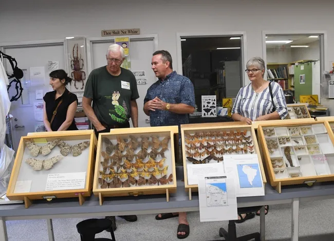 Retired entomologist and UC DAvis alumnus Norm Smith (second from left) talks to visitors at the Bohart Museum of Entomology's "Moth Night." The white witch (see display on the far left) is the largest moth in the world. (Photo by Kathy Keatley Garvey)