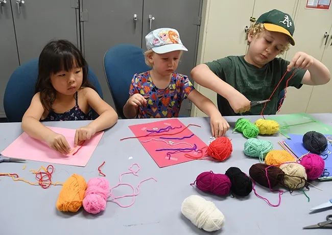 Participating in the family craft activity are (from left) Vacaville residents Rinka Matsumiya, 5, Kate Irwin, 3,
and Kate's brother, Thomas Irwin, 8. (Photo by Kathy Keatley Garvey)