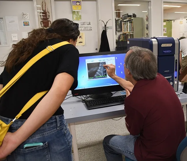 Senior museum scientist Steve Heydon chats with a visitor about parasites. (Photo by Kathy Keatley Garvey)