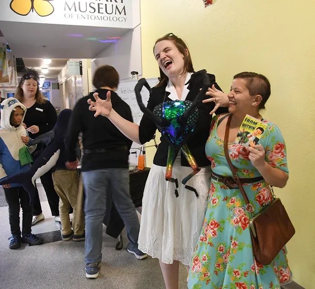UC Davis undergraduate entomology student Karissa Merritt (right) who created the invitations, shares a laugh with doctoral candidate Charlotte Herbert Alberts, who crafted her costume, inspired by the invitation. (Photo by Kathy Keatley Garvey)