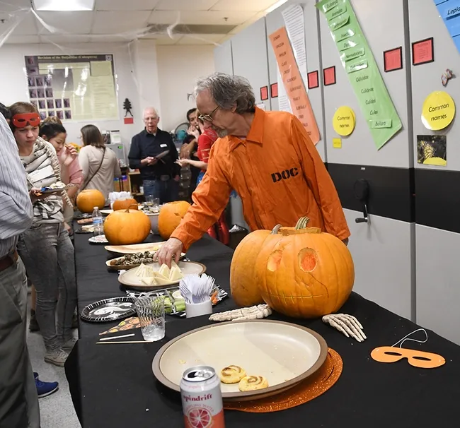 Senior museum scientist Steve Heydon dressed in an orange jumpsuit, lettered in back "Department of Corrections." (Photo by Kathy Keatley Garvey)