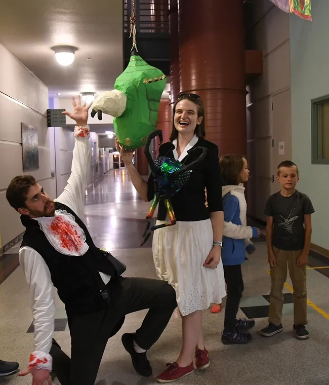 Two co-creators of the monarch chrysalis piñata--Charlotte Herbert Alberts and husband George Alberts--pose with the piñata just before the start of the game. (Photo by Kathy Keatley Garvey)
