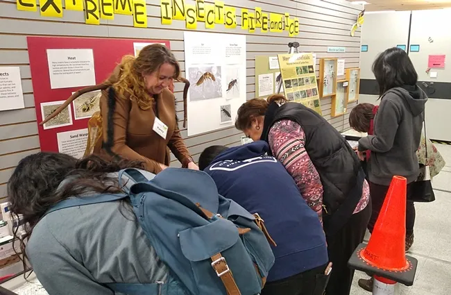 Pests, including cockroaches, drew the rapt attention of this crowd at the Bohart Museum of Entomology. That's Karey Windbiel-Rojas fielding questions. (Photo by Tabatha Yang)