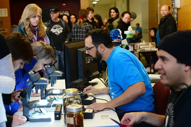 UC Davis doctoral student and nematologist Christopher Pagan shows nematode specimens to visitors at the UC Davis Biodiversity Museum Day. (Photo by Kathy Keatley Garvey)