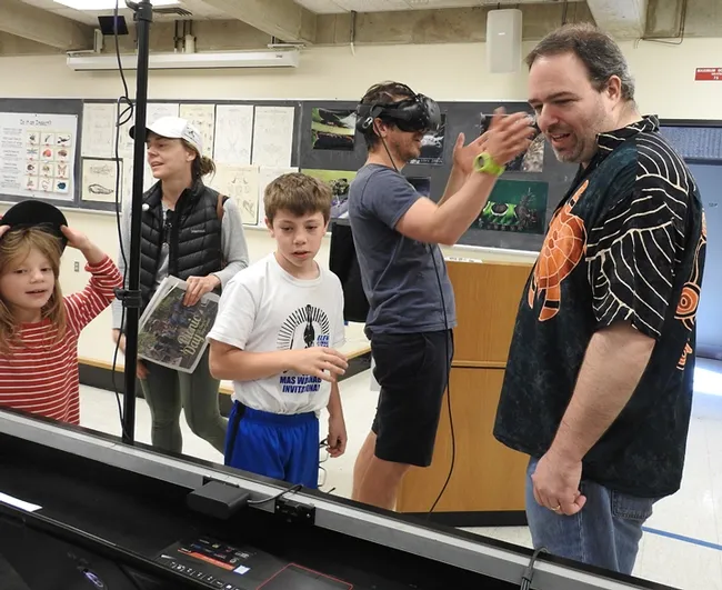 Dad Ethan Ehrlich (background) reacts to the 40-foot-tall bugs. With him are wife Carolina, children Sebastian and Kamila, and UC Davis medical entomologist Geoffrey Attardo. (Photo by Kathy Keatley Garvey)