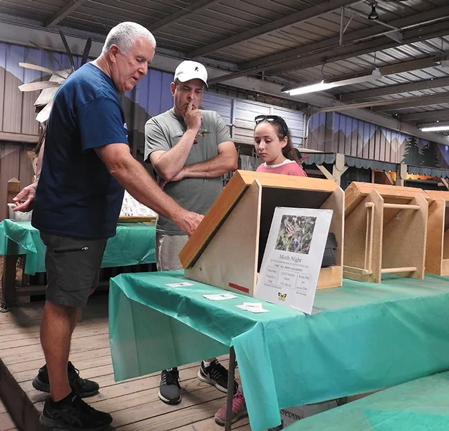 Entomologist Jeff Smith (left) shows insect displays from the Bohart Museum of Entomology to fairgoers last Saturday at the Dixon May Fair. (Photo by Kathy Keatley Garvey)