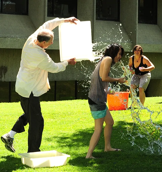 In this 2017 photo, Bruce Hammock douses Louisa Lol, who served as his executive administrative assistant before moving to Michigan. Her husband, Kin Sing Stephen Lee, formerly of the Hammock lab, is on the faculty of Michigan State University's Pharmacology and Toxicology. She serves as an administrative assistant at the university. (Photo by Kathy Keatley Garvey)