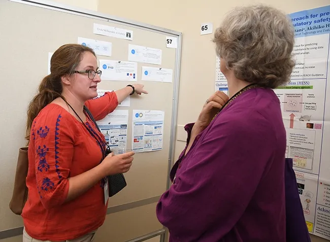 Cindy McReynolds (left) of the Bruce Hammock lab talks about her scientfic poster at the Bruce Hammock Alumni Lab Reunion, held last August at the UC Davis Conference Center. (Photo by Kathy Keatley Garvey)