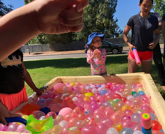 Some 2000 colorful water balloons are ready to be tossed. In the background is water warrior Lea Barnych, 4, whose mother Natalia Vasylieva is a researcher in the Bruce Hammock lab. (Photo by Kathy Keatley Garvey)