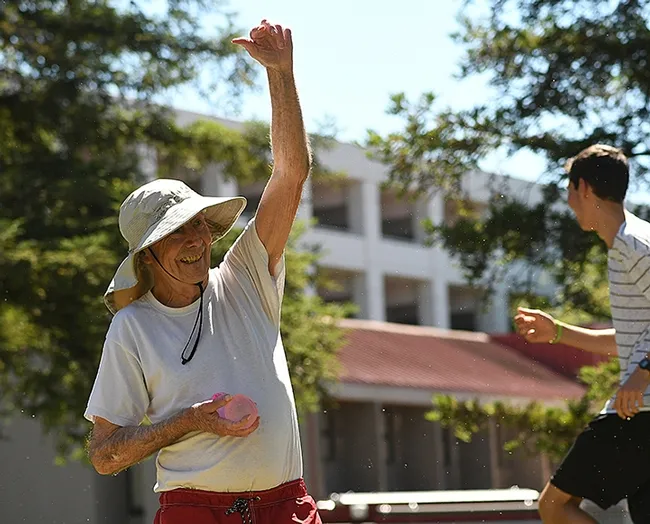 UC Davis distinguished professor Bruce Hammock catches a water balloon tossed at him. (Photo by Kathy Keatley Garvey)