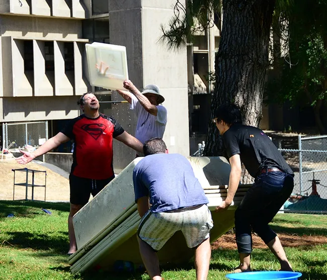 Christophe Morisseau, a researcher in the Hammock lab and coordinator of the Bruce Hammock Lab Water Balloon Battle, gets drenched. (Photo by Kathy Keatley Garvey)