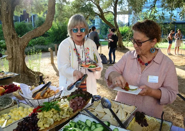 Amina Harris (right), director of the UC Davis Honey and Pollination Center, chats with honey bee veterinarian Terry Ryan Kane of Ann Arbor, Mich., at the Thursday night reception. The Honey and Pollination Center organized the conference.(Photo by Kathy Keatley Garvey)