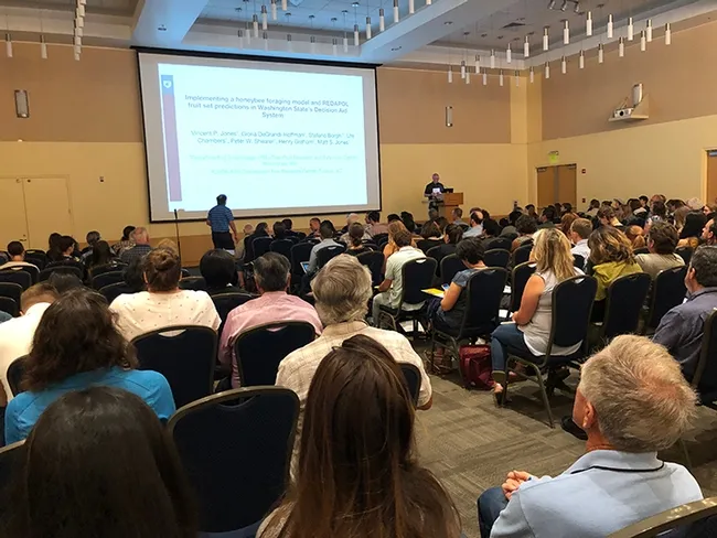 Vince Jones (far right) of Washington State University, Pullman, Wash., addressing the crowd on "Implementing a Honeybee Foraging Model and REDAPOLL Fruit Set Predictions in Washington State's Decision Aid System." (Photo by Kathy Keatley Garvey)