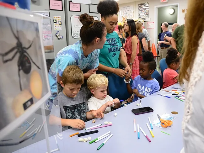 The youngsters work at coloring and stringing together cocoons for bracelets and necklaces. (Photo by Kathy Keatley Garvey)