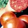 A group of ripe red tomatoes on a cutting board, with one tomato sliced open to show its interior.
If there's additional detail you can provide or specific aspects of the image you want to focus on, let me know!