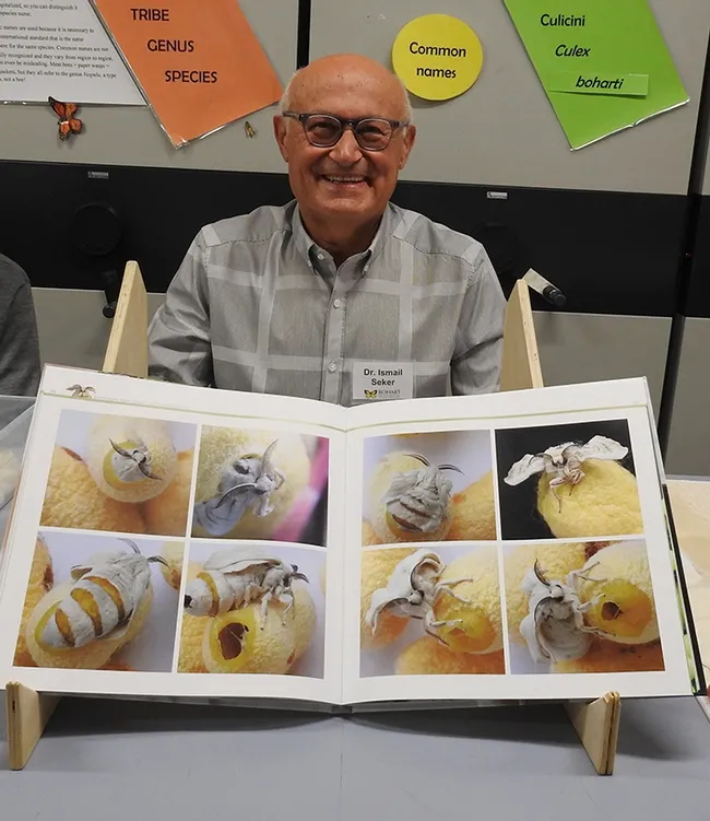 İsmail Şeker with his book containing his macrophotographs.(Photo by Kathy Keatley Garvey)