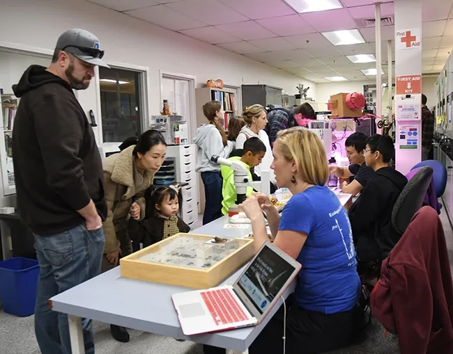 Visitors flock around doctoral student Ann Holmes to see the bat specimens and ask questions. (Photo by Kathy Keatley Garvey)