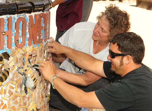 UC Davis entomology professor/artist Diane Ullman and Mark Rivera work on installing an art project at the Häagen-Dazs Honey Bee Haven at UC Davis. (Photo by Kathy Keatley Garvey)