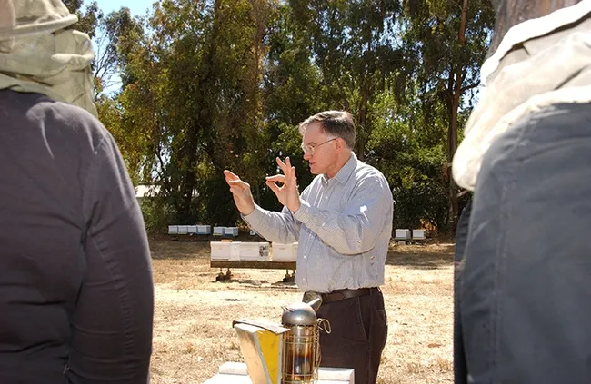 Eric Mussen appears to be conducting an orchestra in this image, taken Sept, 24, 2007, but he is really making a point about bees. (Photo by Kathy Keatley Garvey)