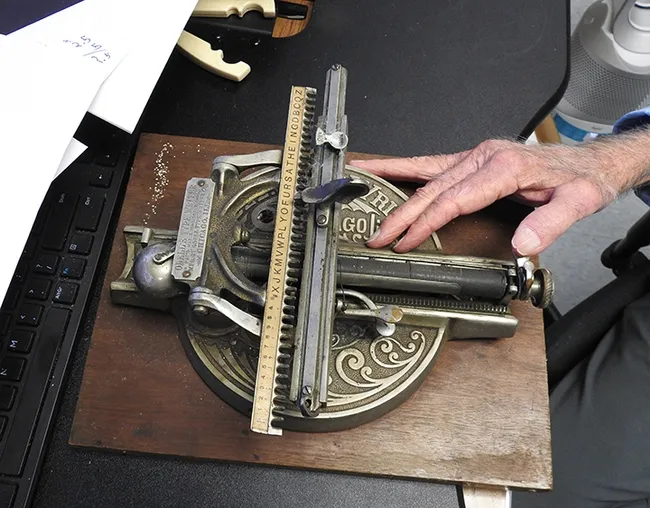 A hand of UC Davis distinguished professor Bruce Hammock rests on the Odell "type writer." (Photo by Kathy Keatley Garvey)